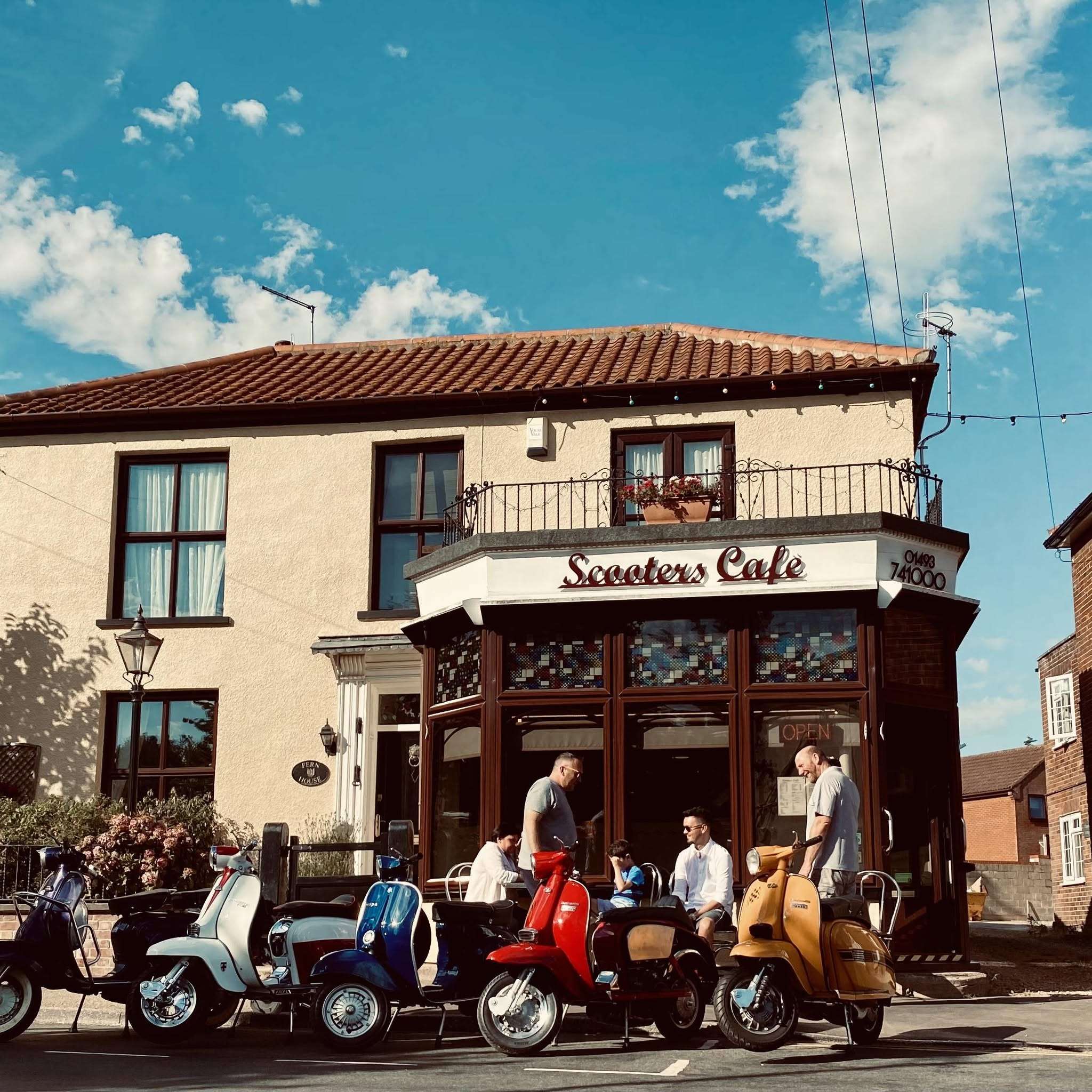Exterior view of Scooters Café in Coltishall, showing outdoor seating and the welcoming café frontage on a sunny day.