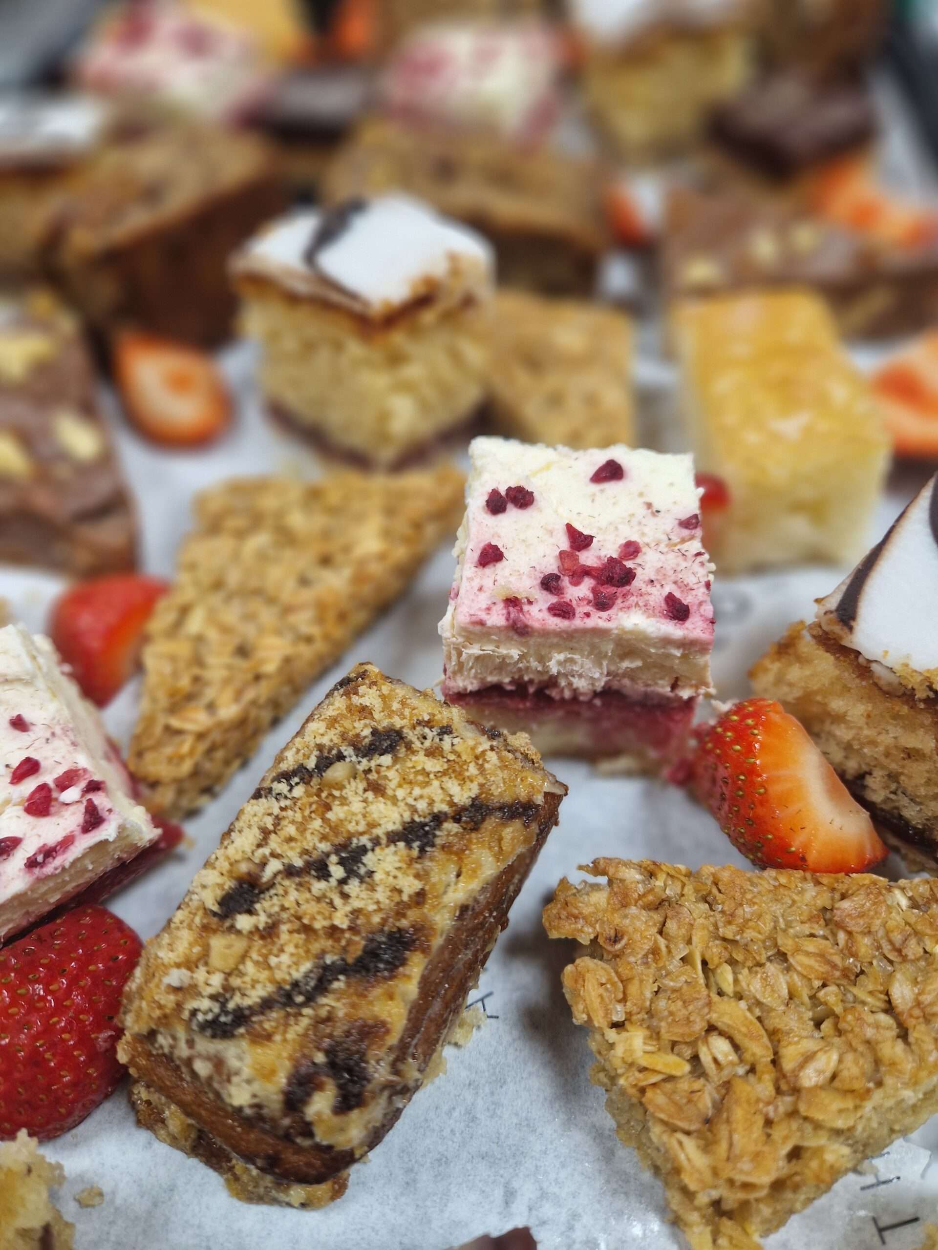 Assorted homemade cakes and traybakes displayed on a serving platter, including fruit slices, sponge cakes and sweet treats.