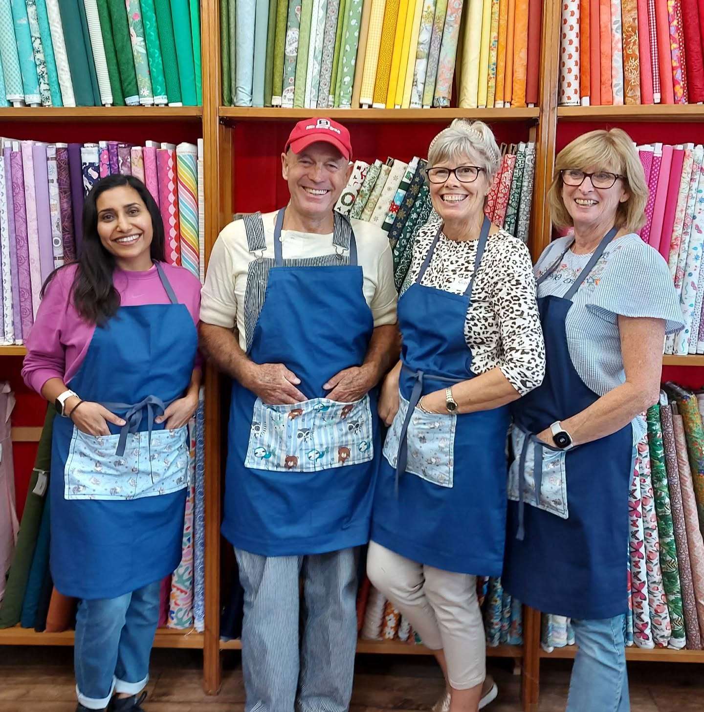 Team members standing inside Albright of Diss, surrounded by colourful fabrics and sewing materials.
