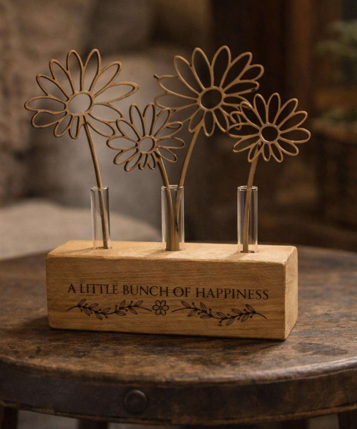Wooden flower sculpture on a natural wood base engraved with the words “A Little Bunch of Happiness”.