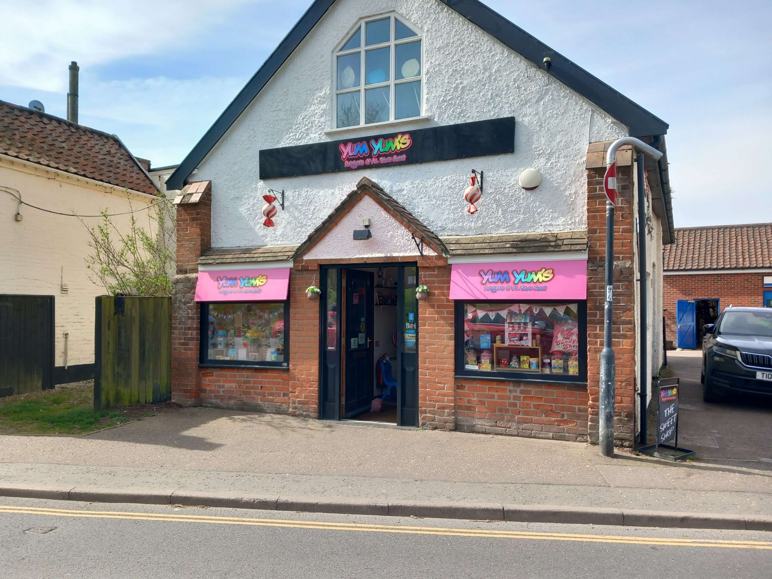 Front exterior of Yums Yums sweet shop in Wymondham with decorative shopfront signage.