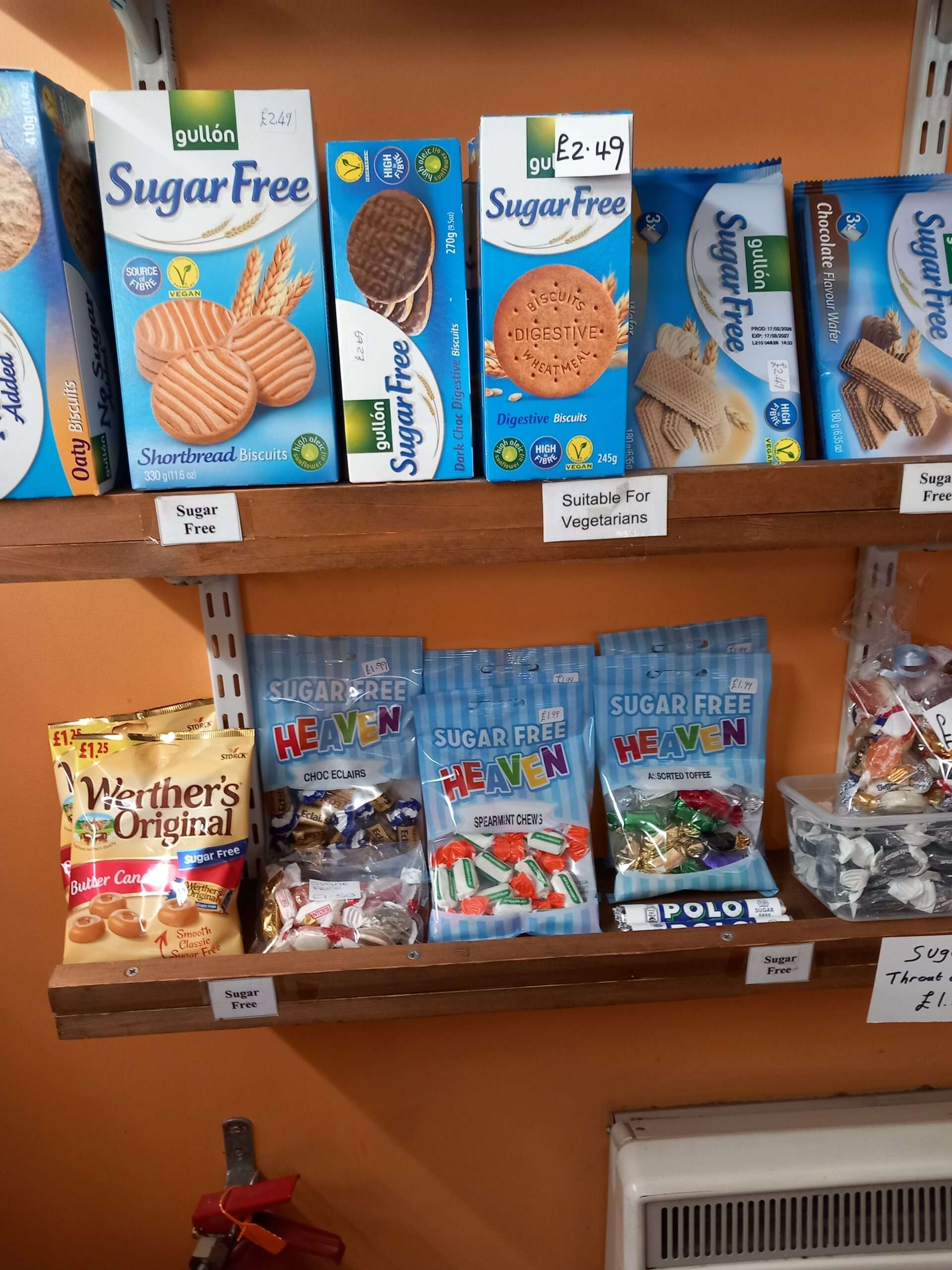 Shelves displaying a variety of sweets, snacks and confectionery products inside Yum Yums Wymondham