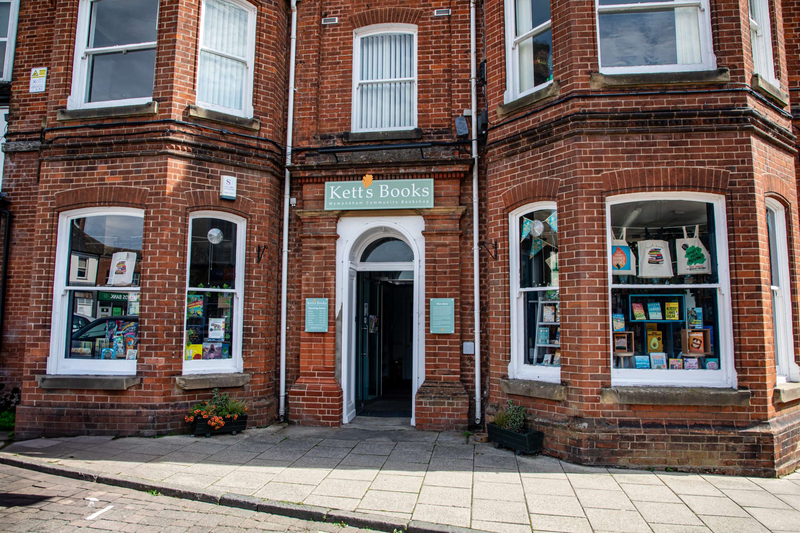 Historic red-brick exterior of Kett’s Books in Wymondham, showing the shop entrance and display windows.