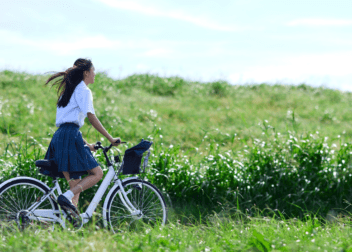 Cyclist riding across open countryside on a sunny day.