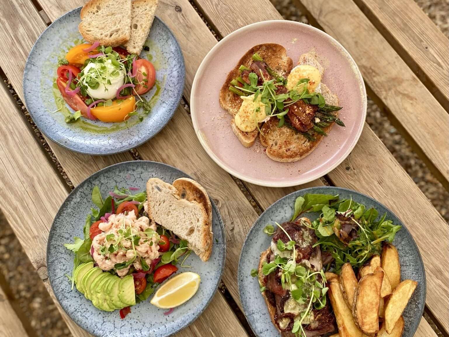 Selection of freshly prepared brunch dishes served on plates with salads and artisan bread.