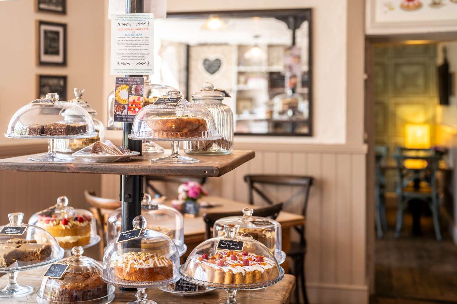 Tea room counter displaying cakes, pastries and refreshments in a cosy setting.
