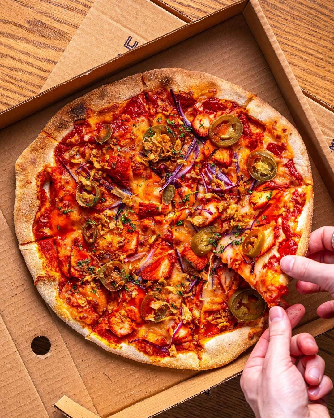 Freshly baked stone-baked pizza topped with vegetables and melted cheese.