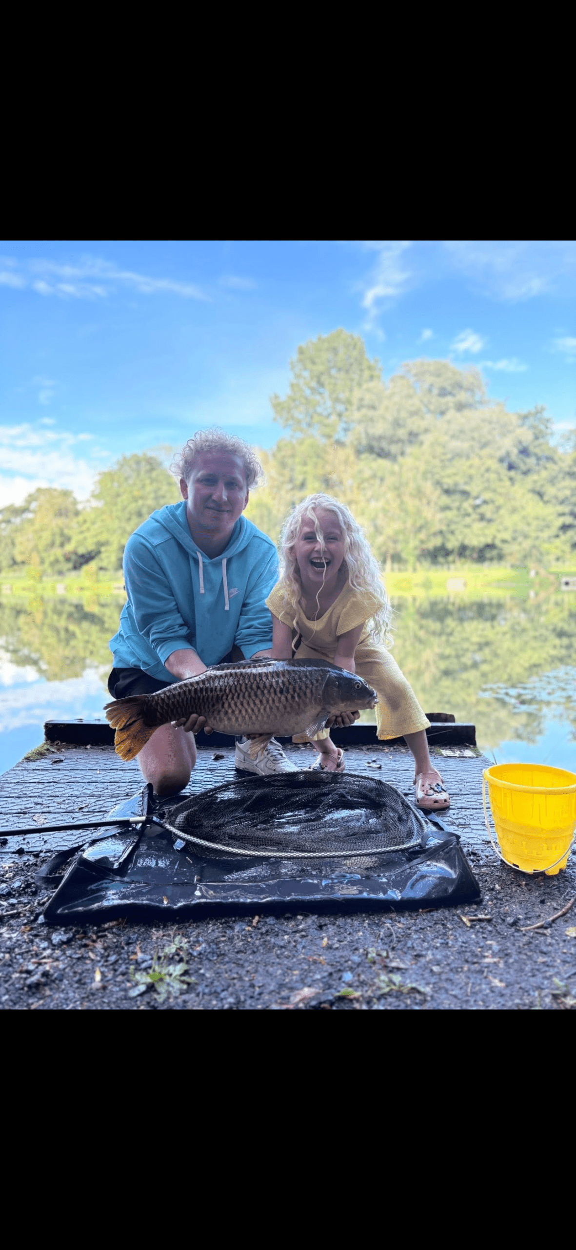 Visitor seated beside a large fish at Barford Lakes, showcasing a successful day's angling.